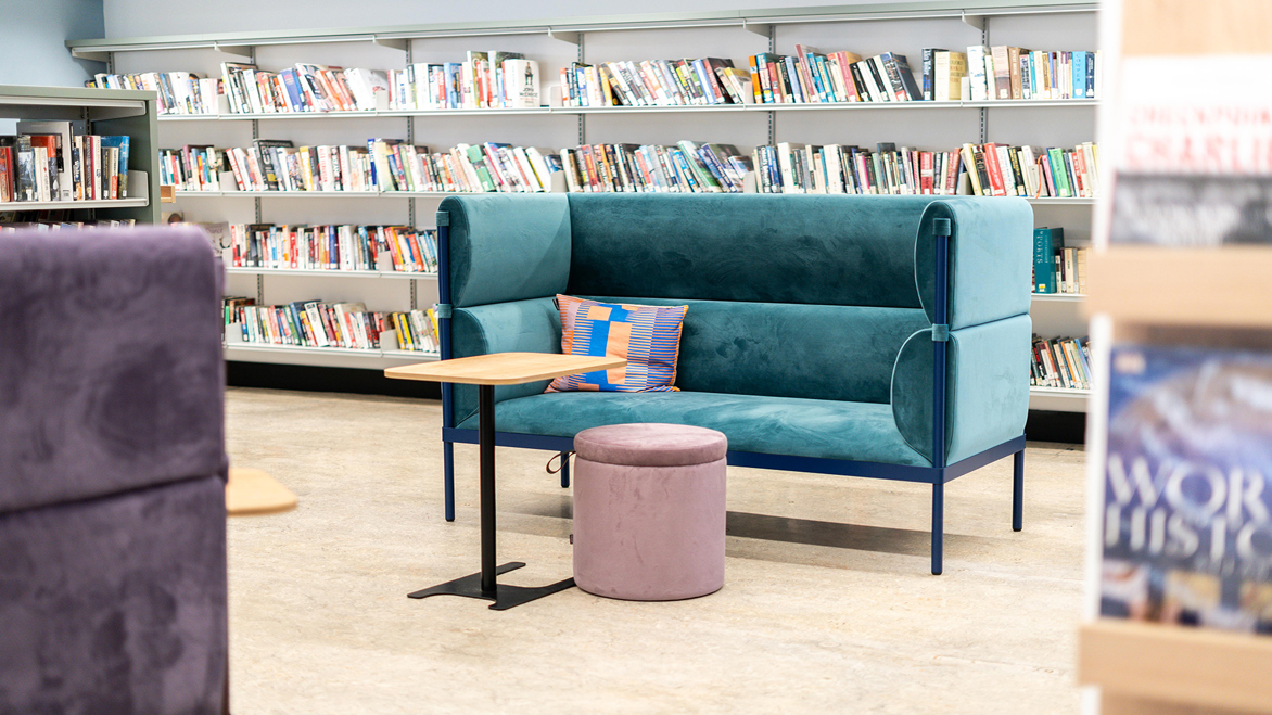 Large comfy teal coloured sofa inside the library