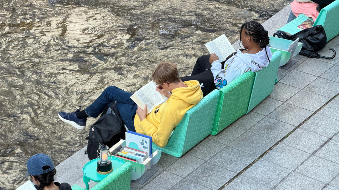 Library visitors sitting on colourful outdoor chairs