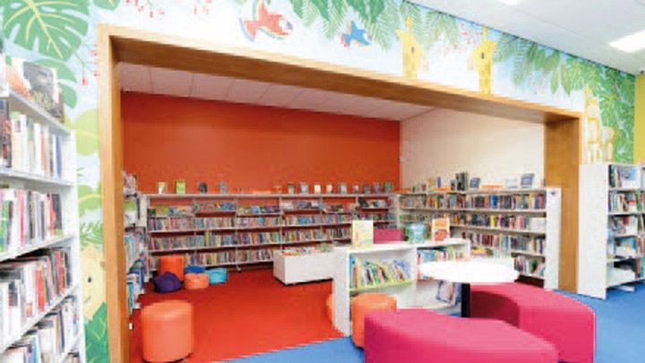 undefinedMountain Ash Library book shelves with colourful and artistic mural area