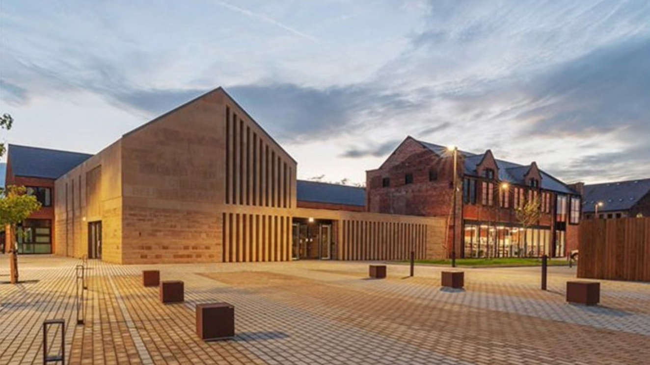 A photograph showing the exterior of Belper Library lit up in the dusk