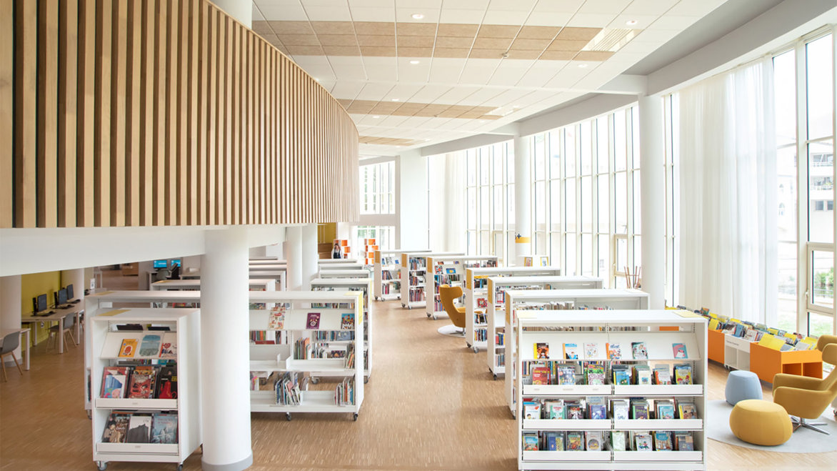 Spacious interior full of white bookshelves and wooden panelling 